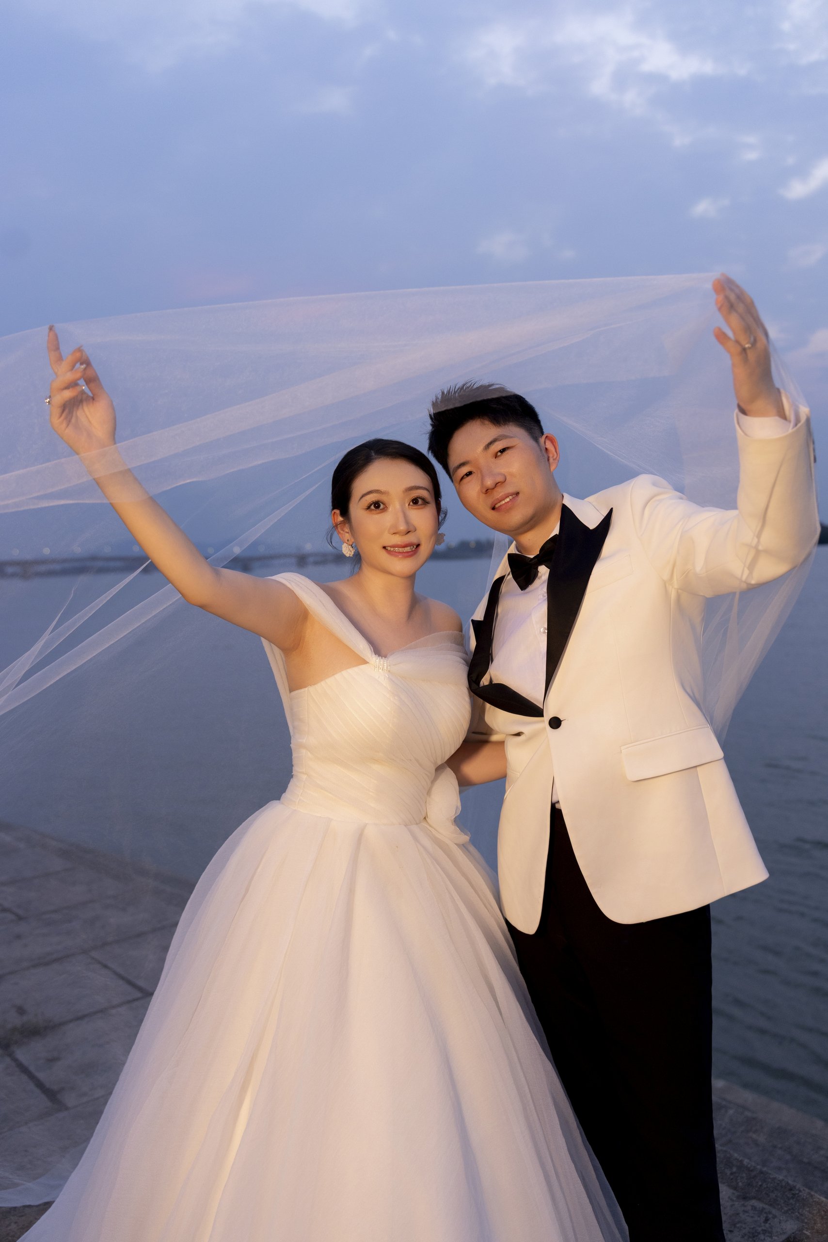 蓝调湖畔新人扬起头纱合影